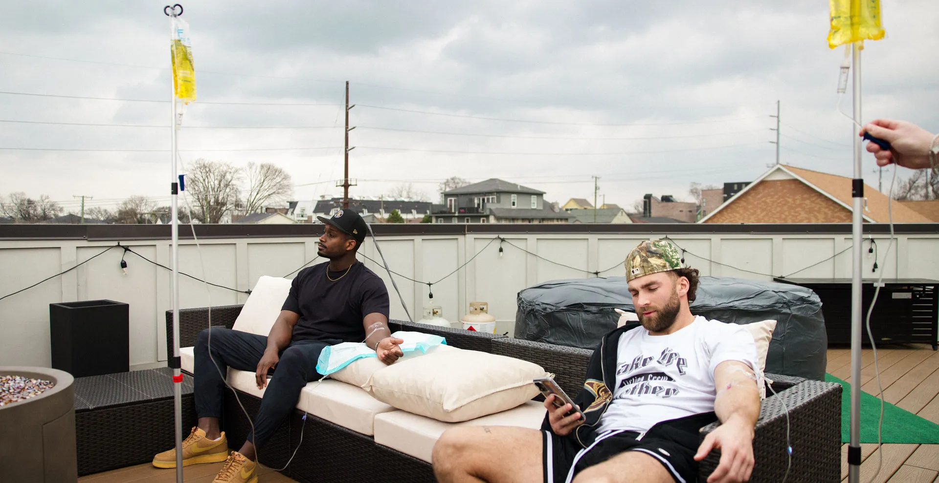 Two friends receiving IV therapy on a Nashville rooftop